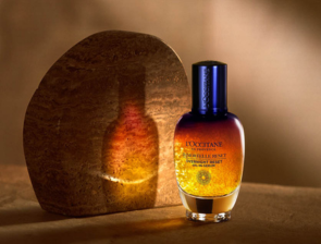 L'Occitane Immortelle Overnight Reset Serum – dunkelblaues Flakon vor warmem Steinbogen im Gegenlicht