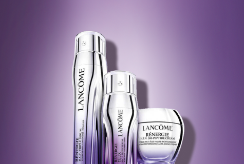 Lancôme Hautpflegeprodukte, darunter Cremes und Seren in silbernen Verpackungen, vor einem violetten Hintergrund.