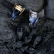 Invictus Parfumkollektion von Rabanne mit Flakons in Pokalform auf nassen Steinen.